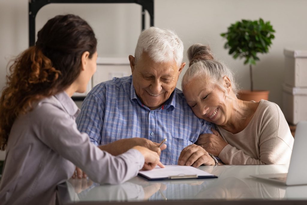 elderly couple signing a contract