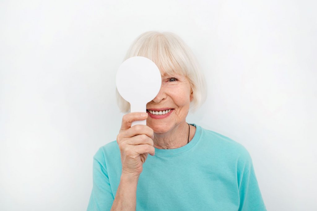 Smiling older lady pondering cataract surgery - does Medicare cover cataract surgery in 2023?