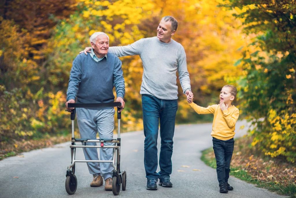 adult man acting as a family caregiver for his elderly father and his young son