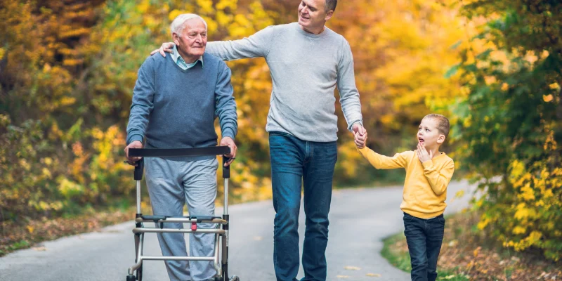 adult man acting as a family caregiver for his elderly father and his young son