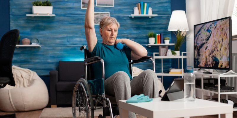 senior woman in wheelchair lifting weights