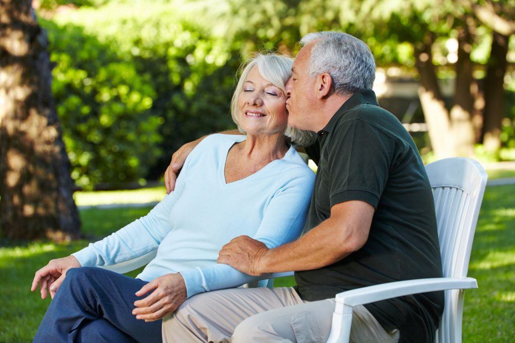 Baby Boomer couple sitting on a bench at the park