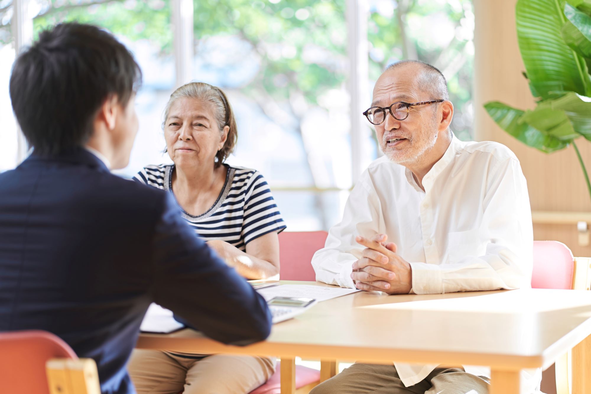 elder law attorney sitting at table talking with a senior couple