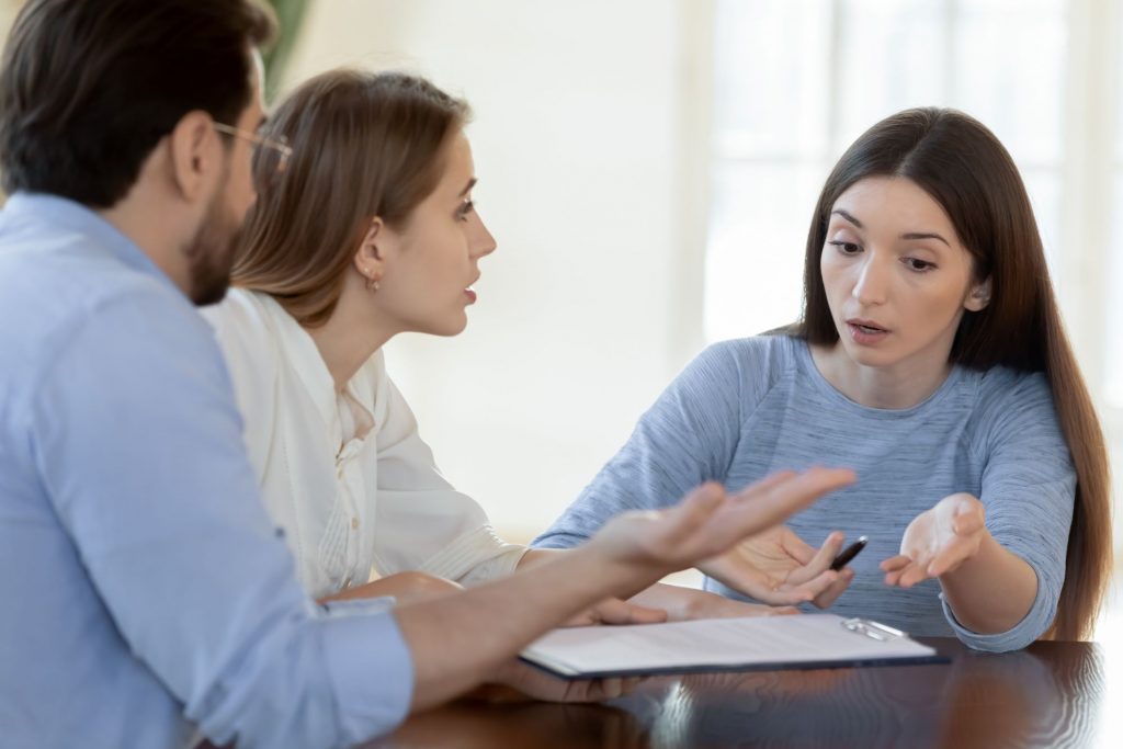 3 people sitting at table arguing over an  underaccomplished estate plan