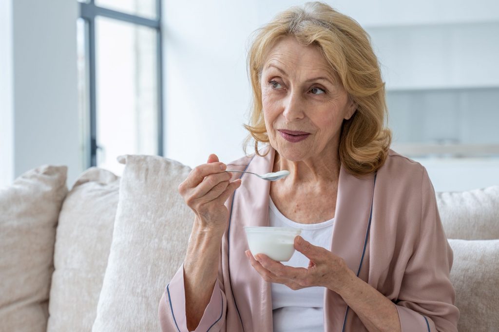 senior woman eating yogurt