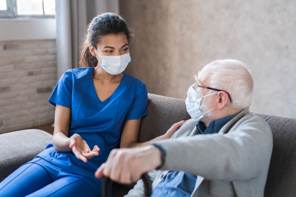 home care nurse and senior man wearing masks