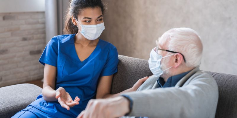home care nurse and senior man wearing masks