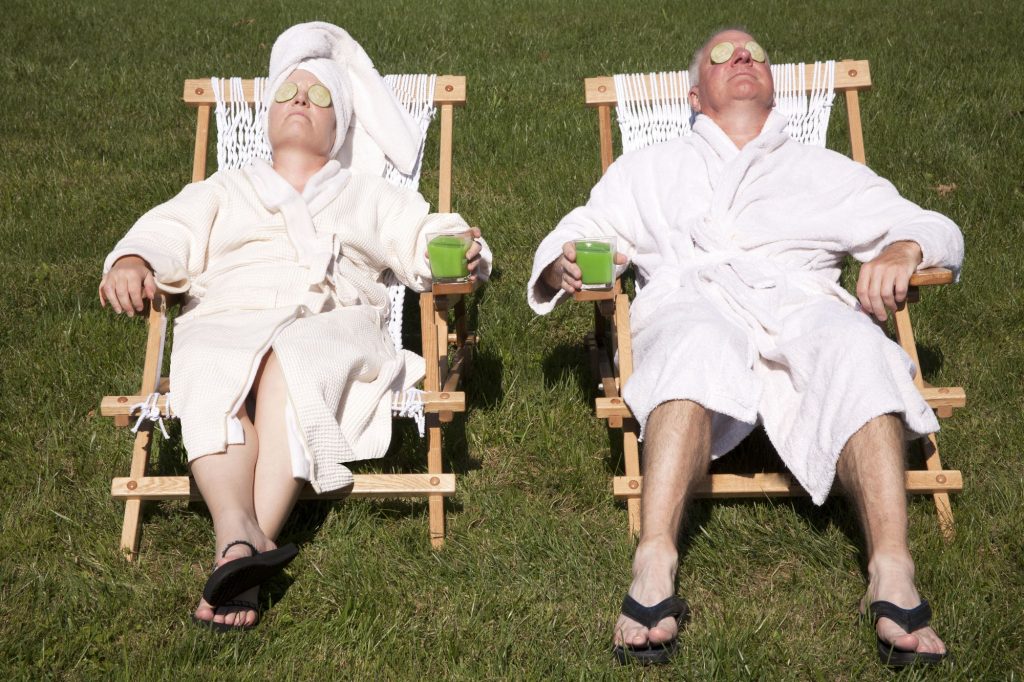 two retirees lounding in bathrobes with cucumbers on their eyes, retirement lifestyle