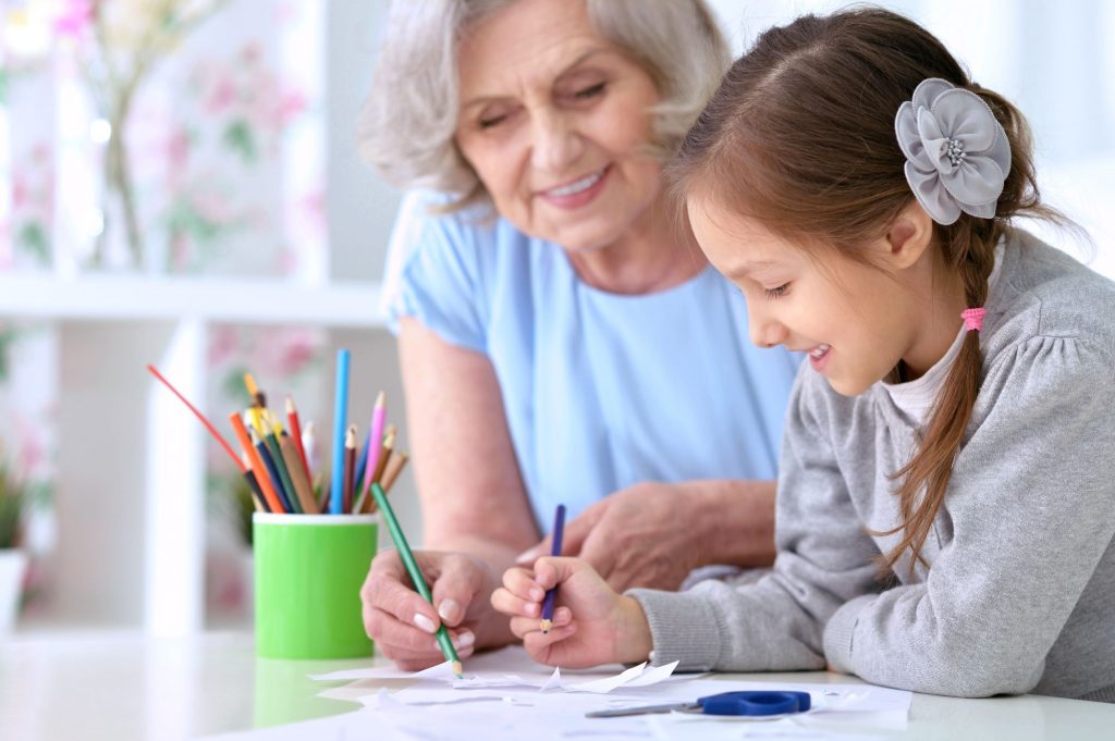grandma and girl with pigtails drawing together