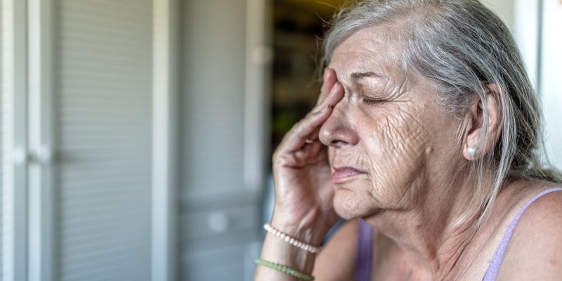 senior woman with hand over eye, sad or in pain