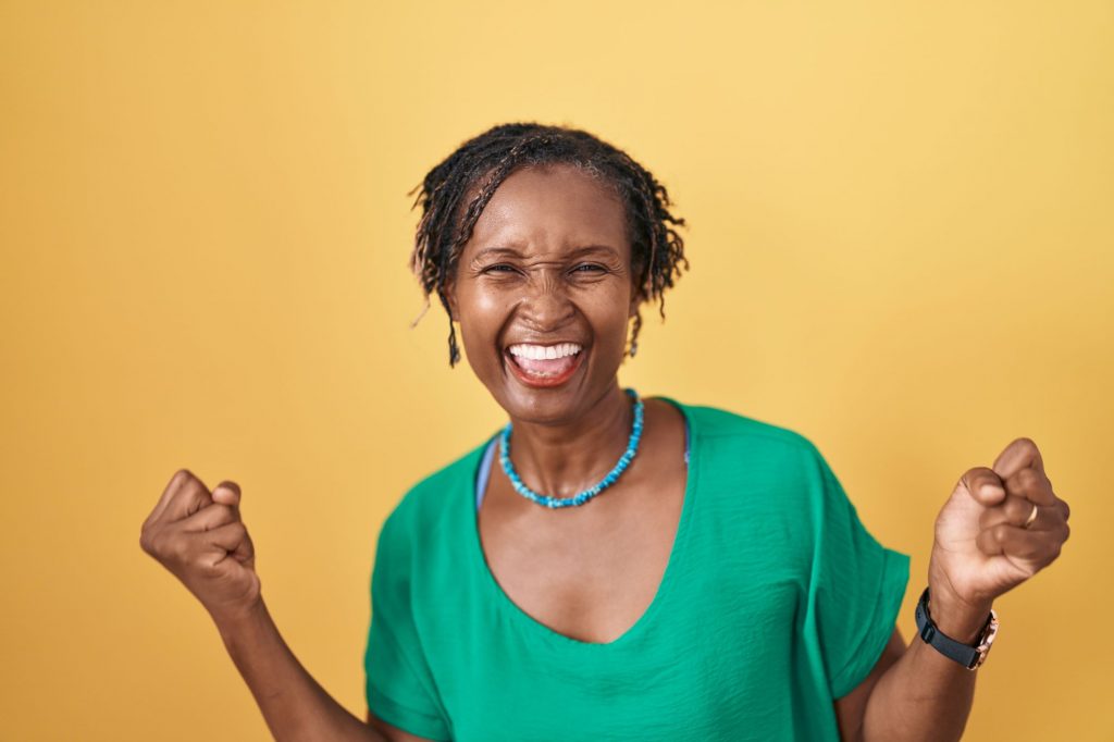 happy strong African-American woman with yellow background