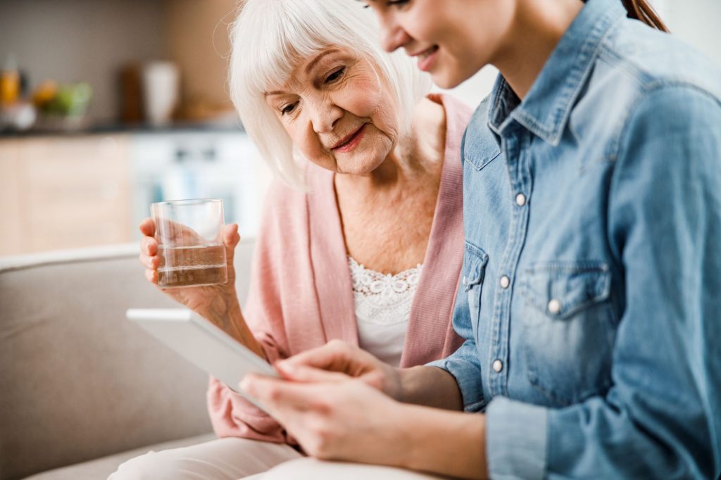 senior mom and grown daughter looking over finances