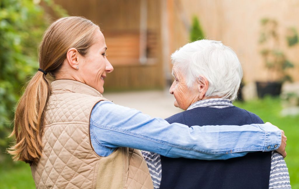 senior and adult child walking outside