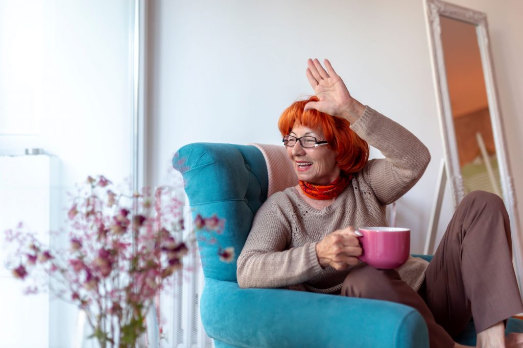 senior woman waving out her window