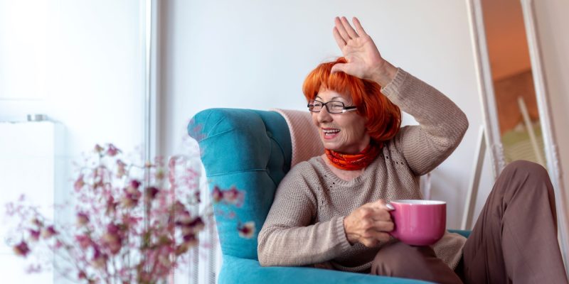 senior woman waving out her window