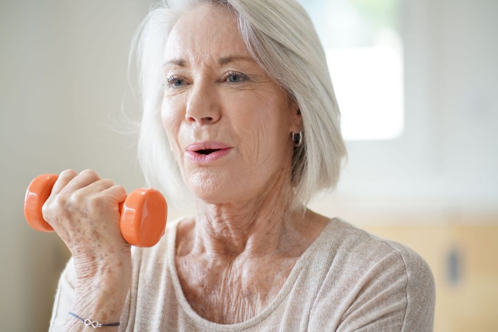 close up of a woman exercising with a dumbell
