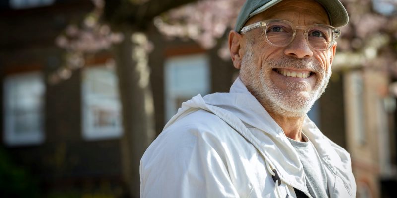 smiling senior man outside wearing a hat