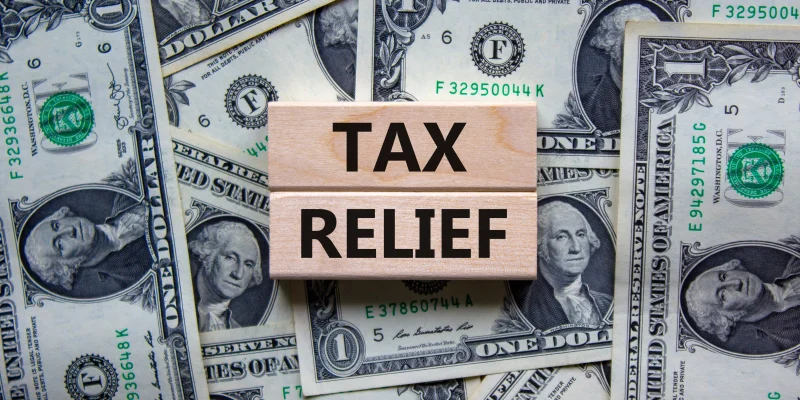 tex reflief words over a whole bunch of dollar bills