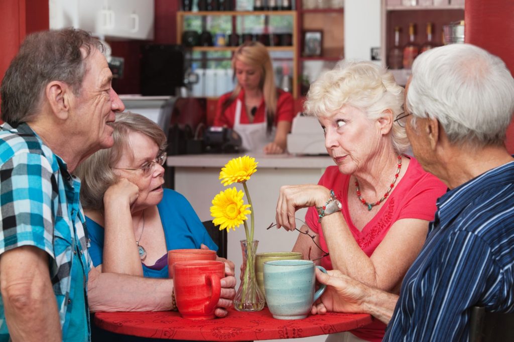 seniors sitting at a table gossiping