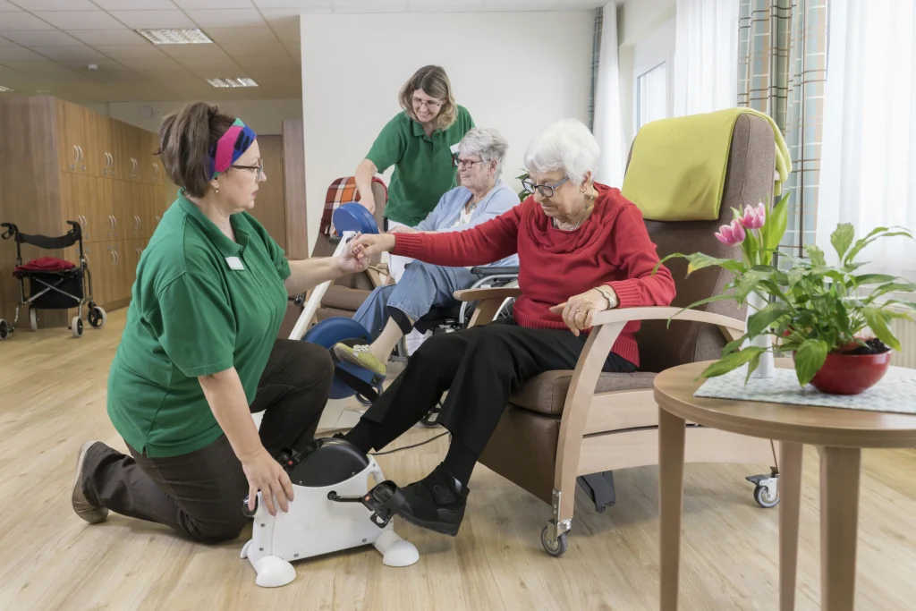 senior women in an adult day care doing exercise with nurse/physical therapists