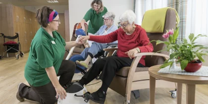 senior women in an adult day care doing exercise with nurse/physical therapists