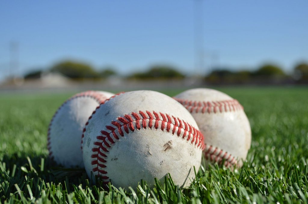 baseballs sitting on grass outside