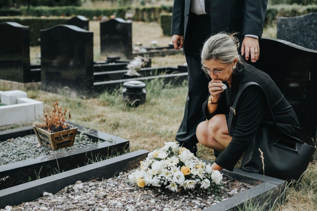 senior woman grieving at a funeral outside