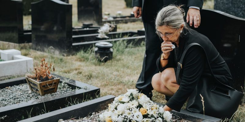 senior woman grieving at a funeral outside