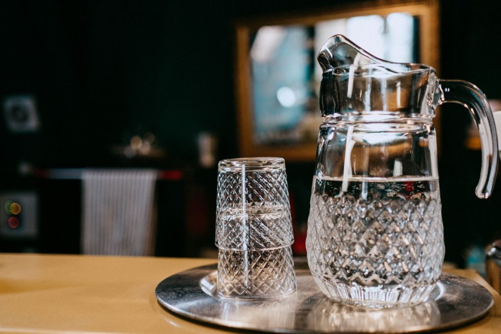 glass water pitcher and glasses on a table