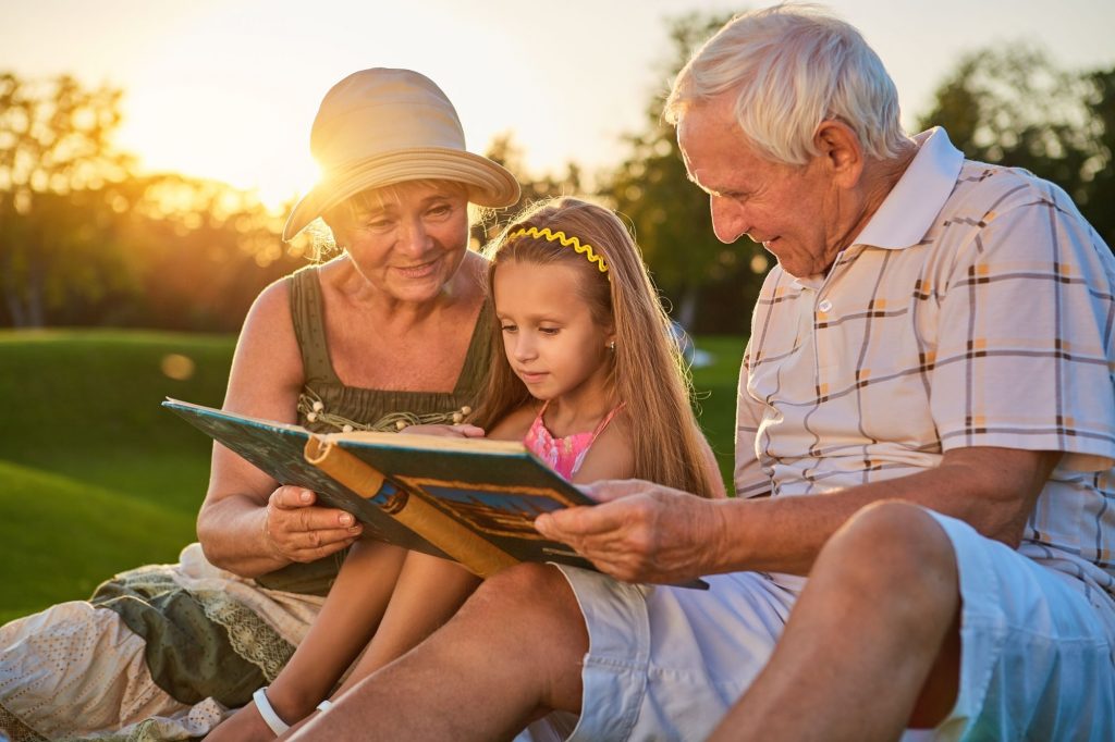 grandparents with little girl reading bible