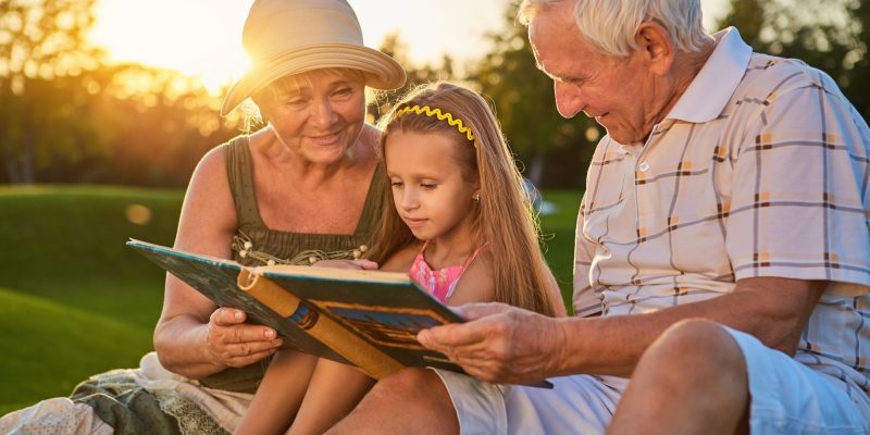 grandparents with little girl reading bible