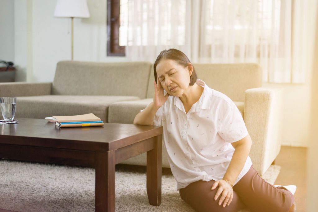 senior on the ground by a coffee table