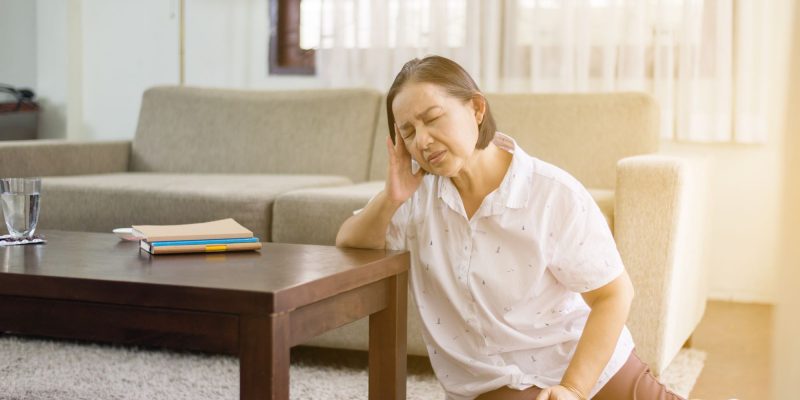 senior on the ground by a coffee table