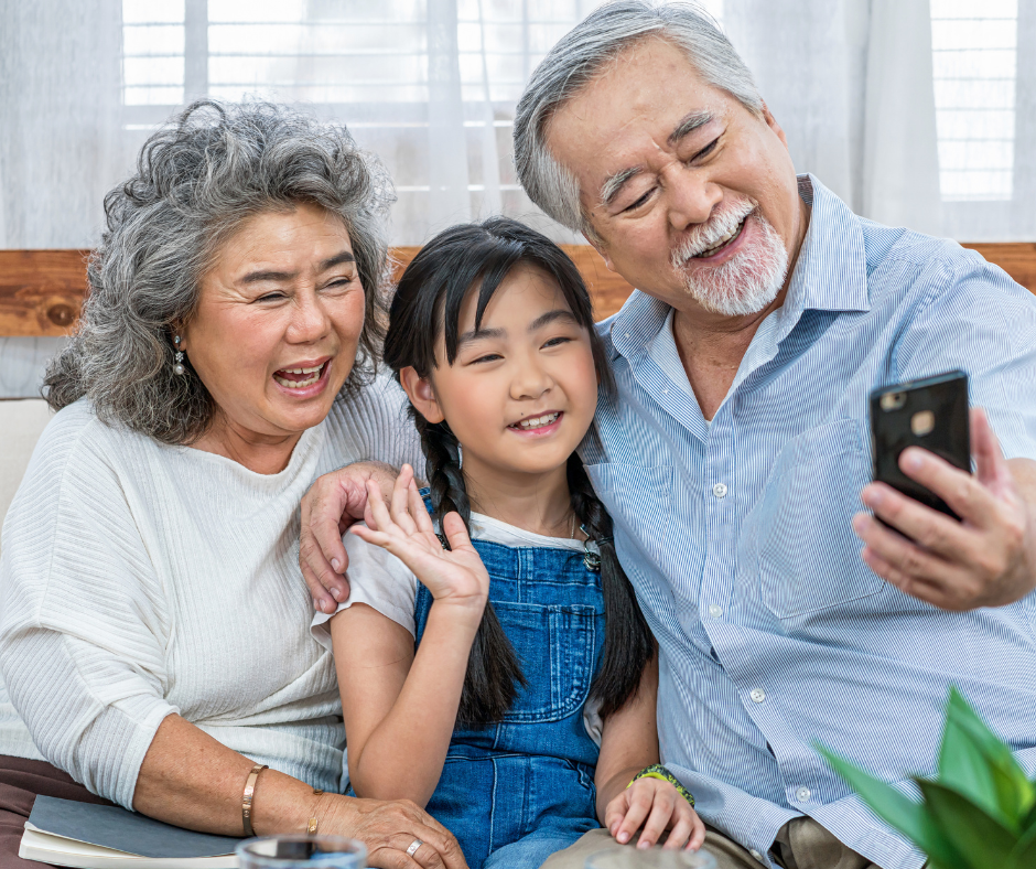 Asain grandparents and grandchild using a phone together