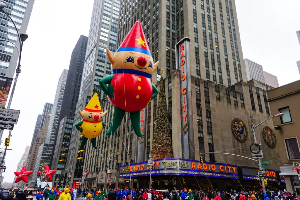 The annual Macy's Thanksgiving Day parade along Avenue of Americas with many balloons floating in the air. Manhattan, New York, USA