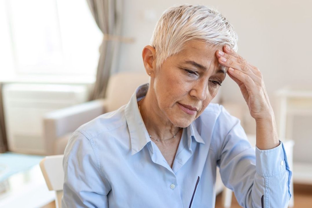 senior woman sitting at a computer looking stressed