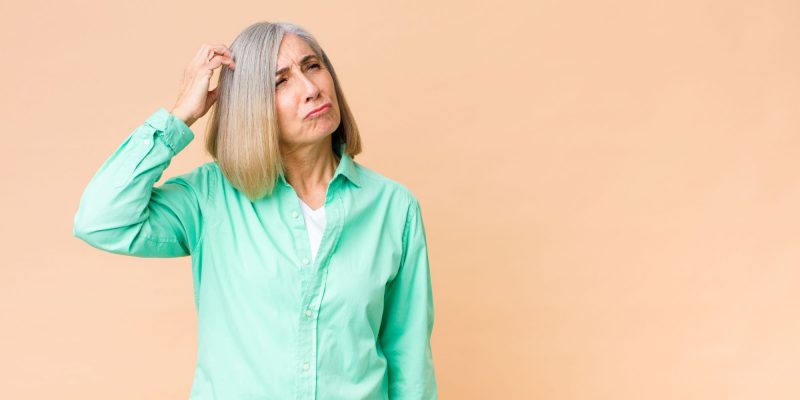 seninor woman scratching head thinking