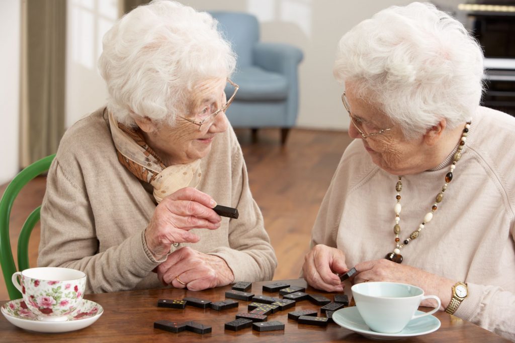 two senior women playing dominoes