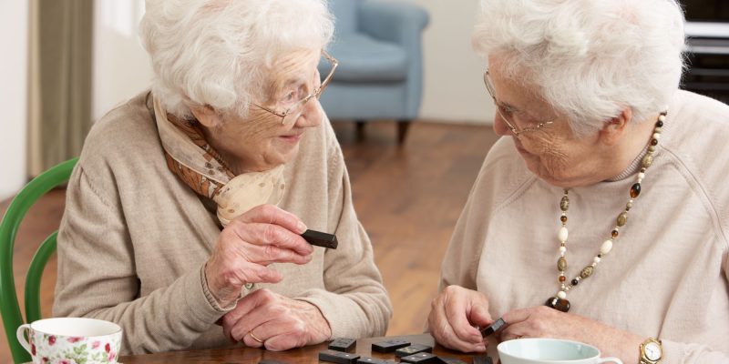 two senior women playing dominoes