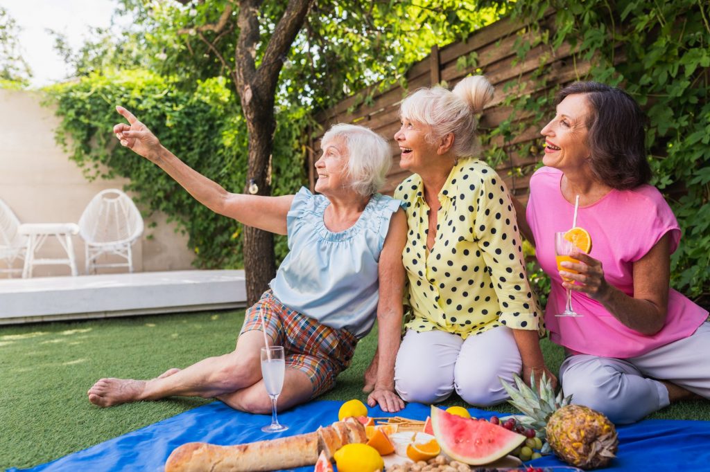 senior women friends in a retirement community setting, active adult community, having a picnic