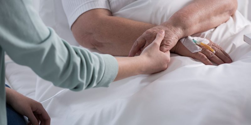 holding hands in a hospital bed