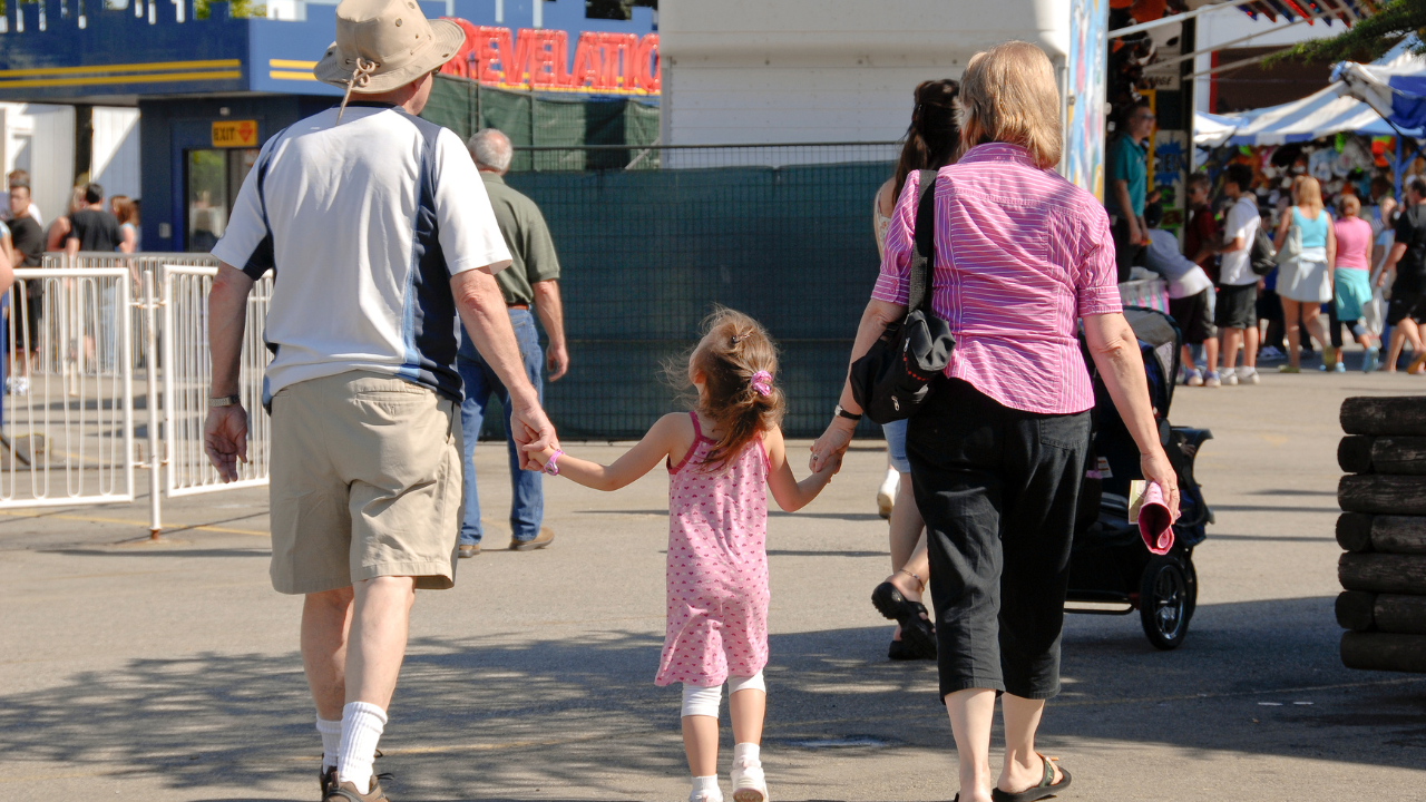 grandparents and granddaughter at a fair