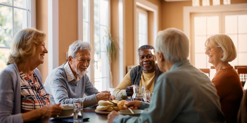 friends in a 55+ active adult community, sitting at a table talking