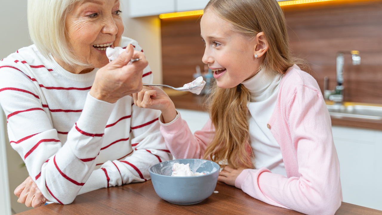grandmother and granddaughter eating ice cream together