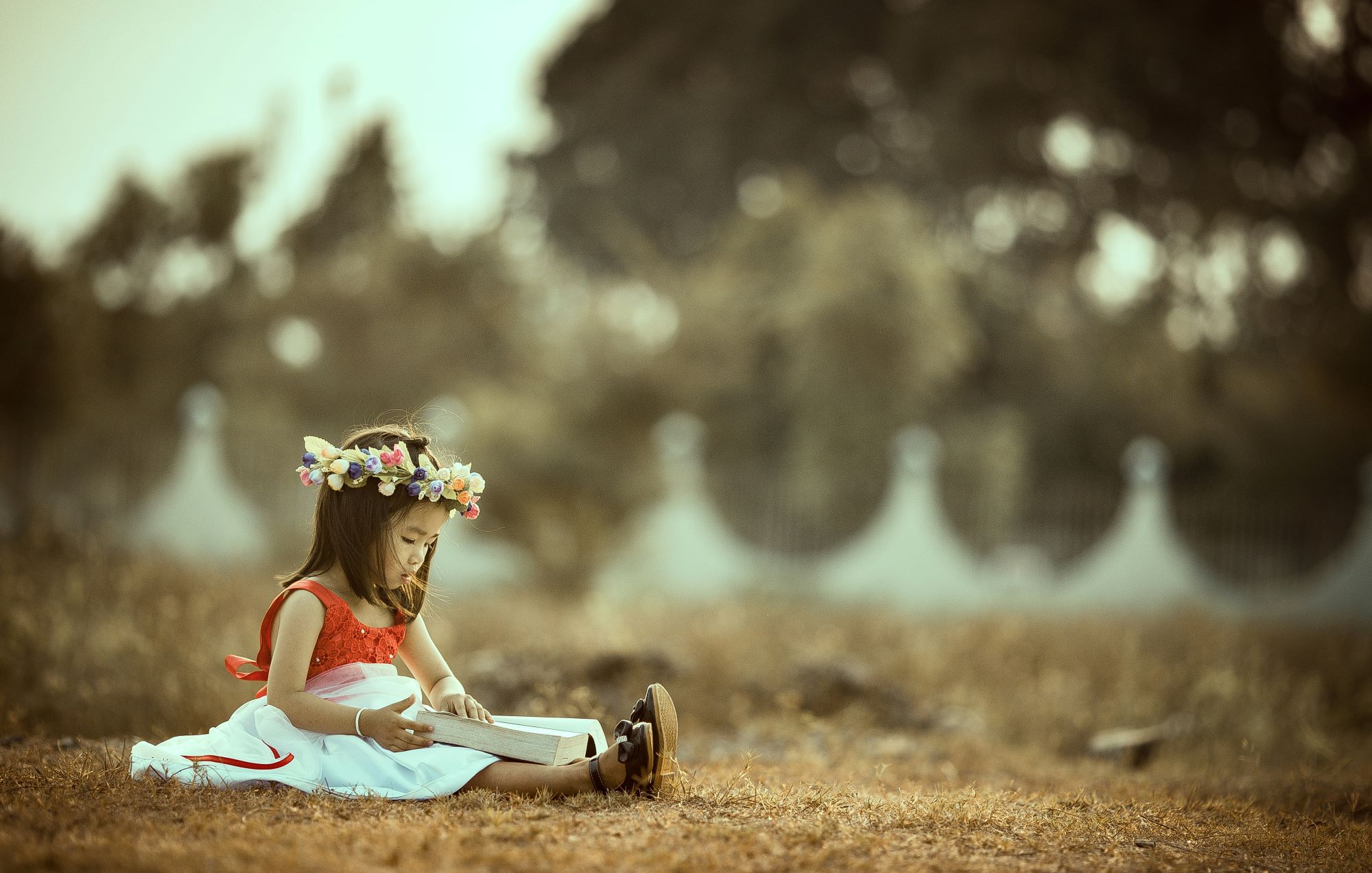 little girl reading a book dressed like a fairy princess