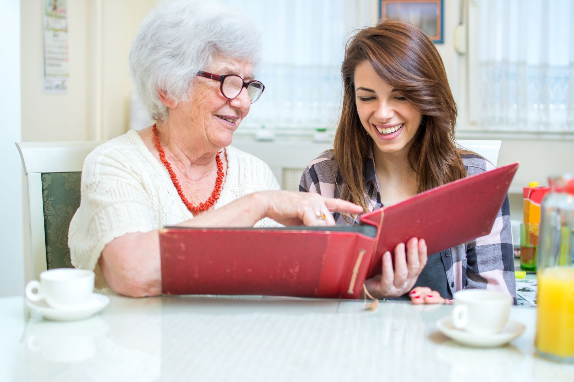 elderly loved one sharing old photos with granddaughter