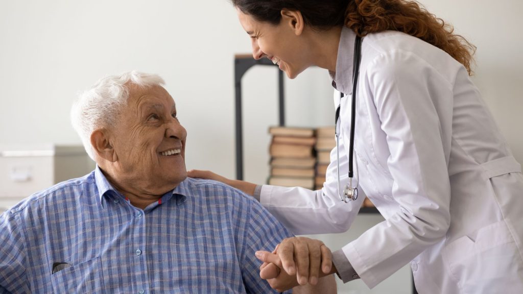 gray haired senior man smiling with female doctor