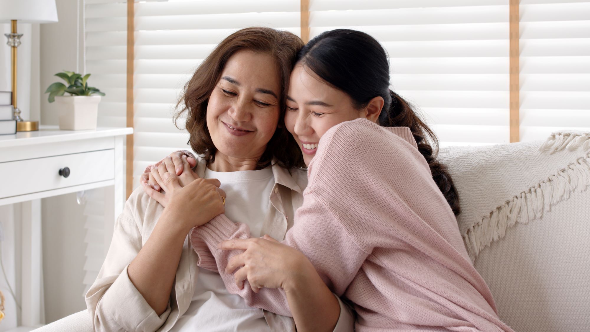 mom and daughter hugging on the courch, asain-american