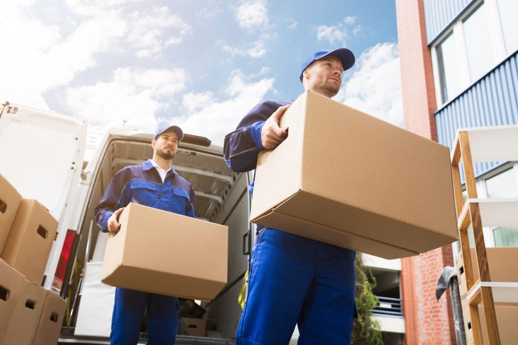 two movers with boxes and a moving truck