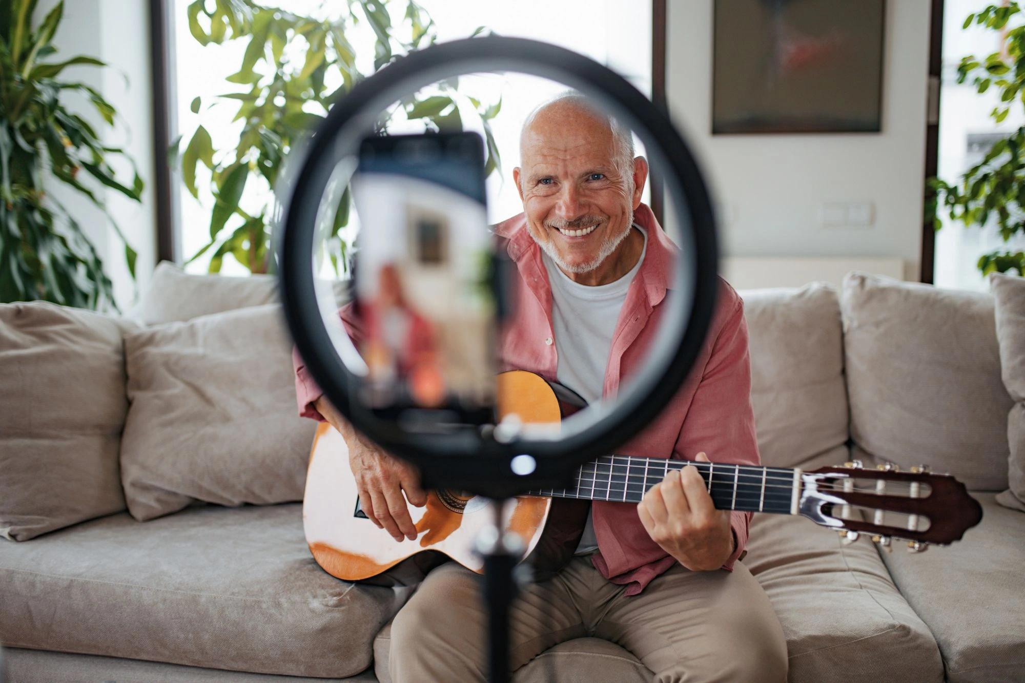 older man senior recording himself music teacher guitar